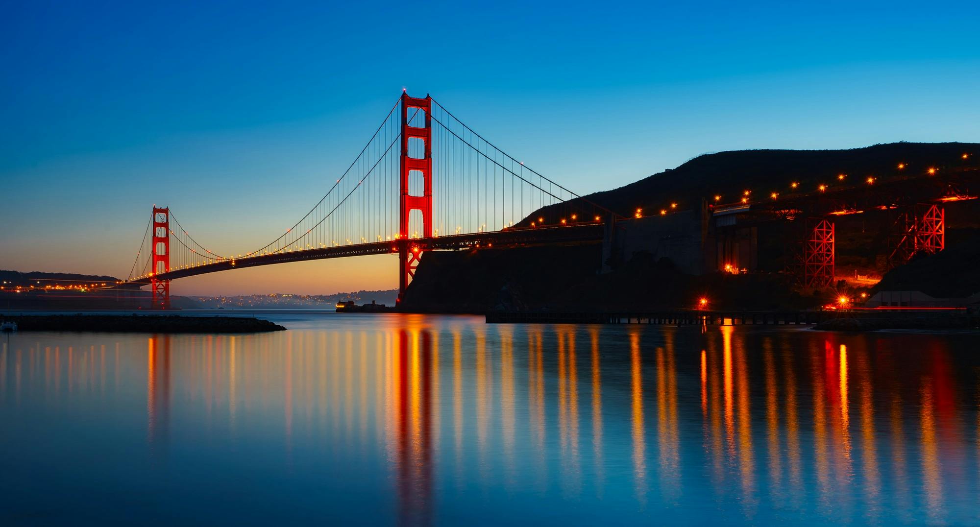 Golden Gate Bridge reflecting in the water during sunset in San Francisco. Iconic architectural landmark.